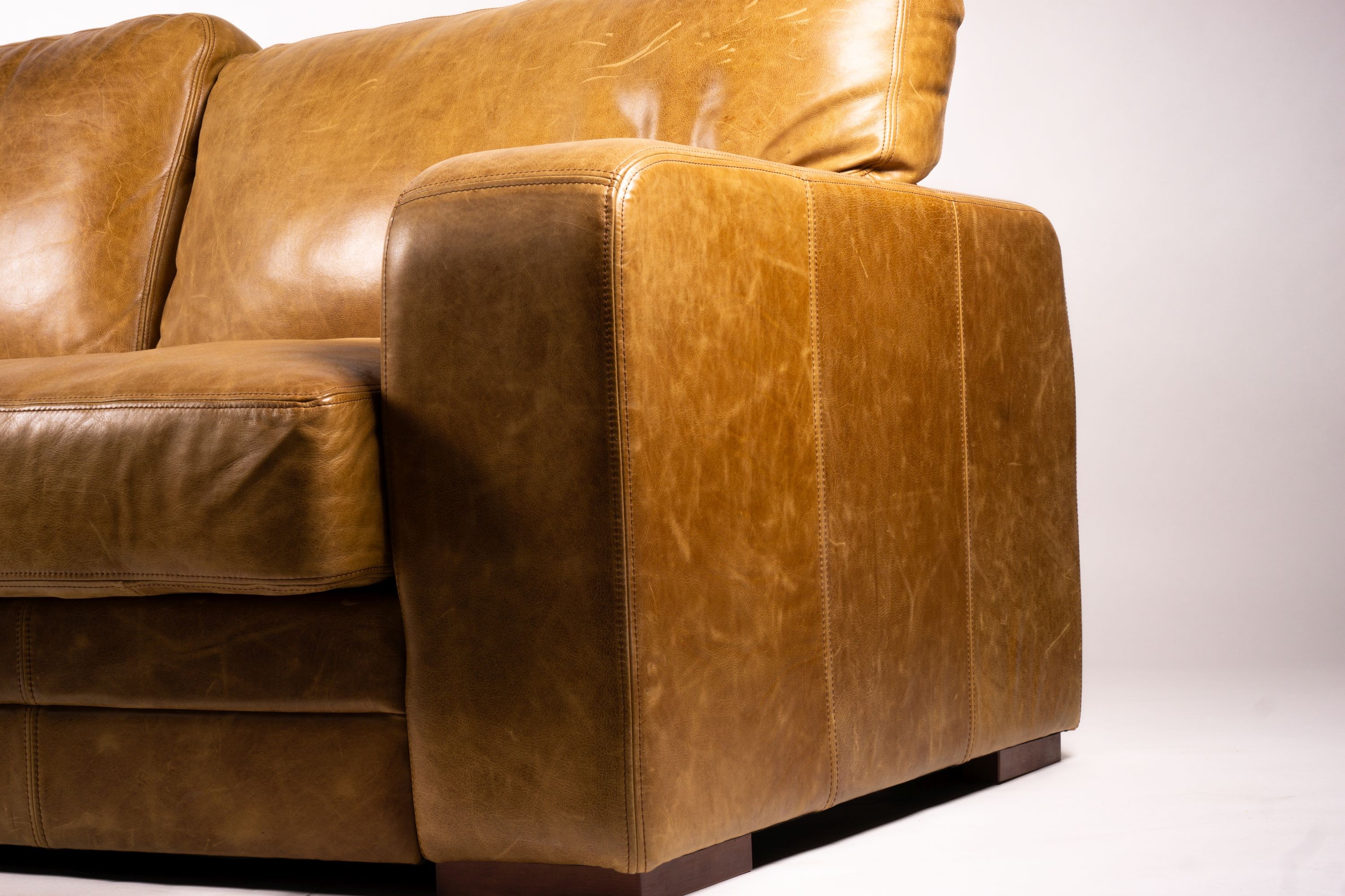 A pair of contemporary tan leather settees, length 200cm, depth 100cm, height 94cm